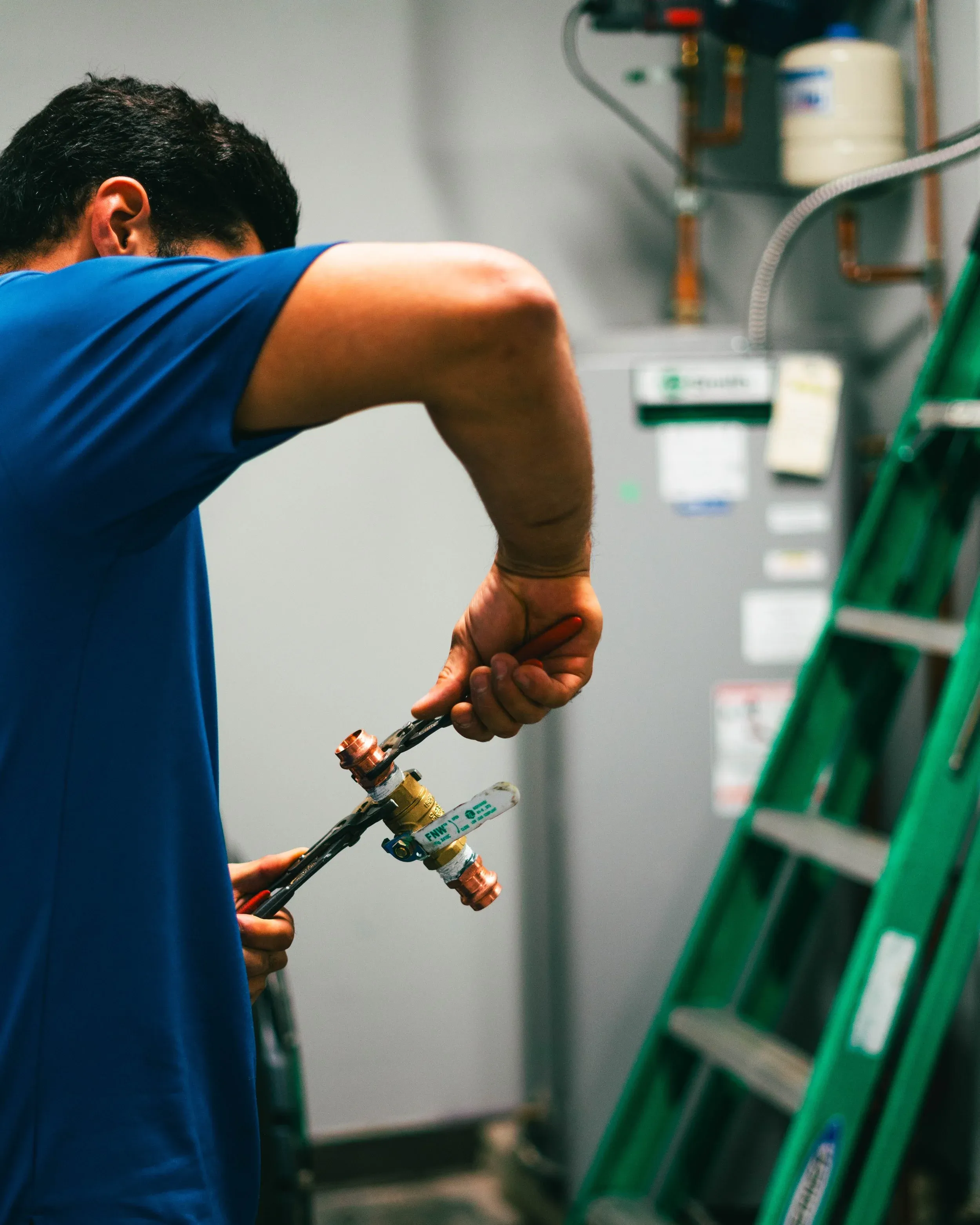 D&D plumber using a wrench on a commercial install