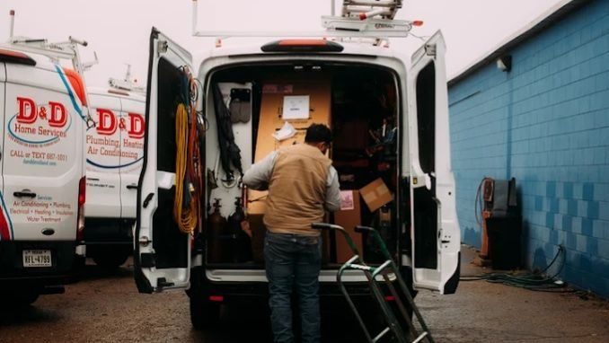 D&D Plumbing, Heating, and Air Conditioning service technician loading equipment into a fully stocked service van before heading to a residential plumbing repair appointment.