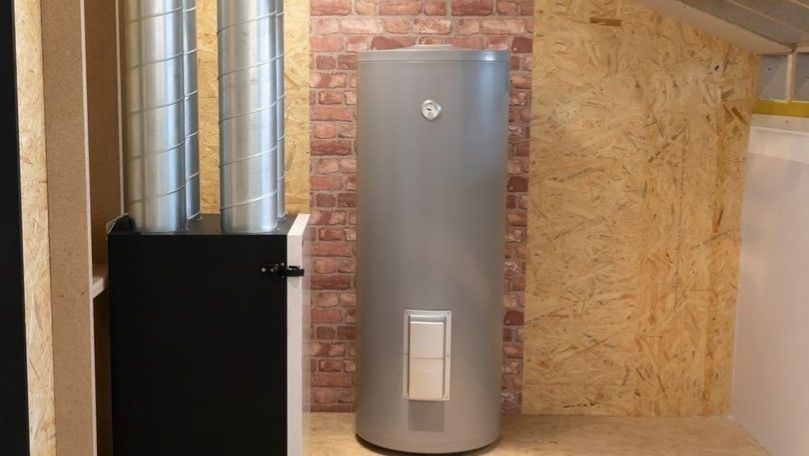 Residential tank water heater installed in a utility room with nearby HVAC ductwork, ready to provide reliable hot water for the home.
